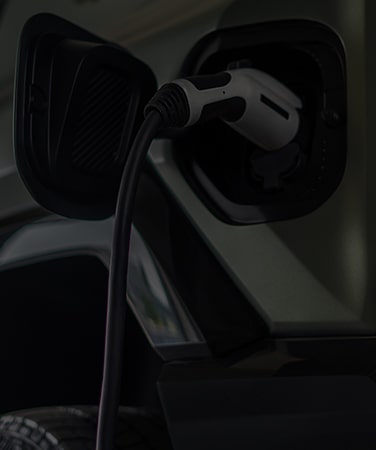 Electric Vehicle Plugged into Charging Station with Text Overlay "Electrification"