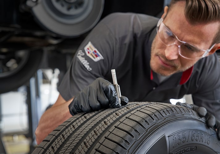 Cadillac Technician Checking the Tread Condition on a Tire