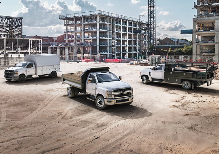 Fleet Work and Utility Trucks Parked In Front of a Construction Site