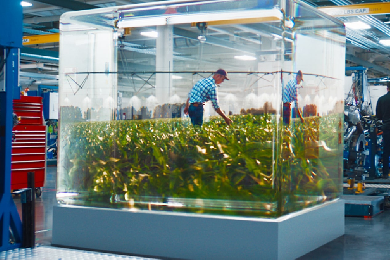 A Man inside a Glass Box Working on Plants in a Warehouse